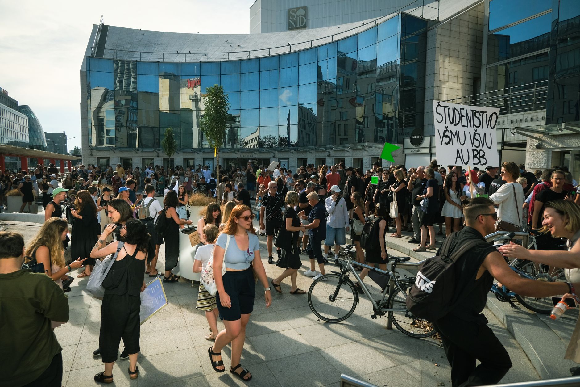A large peaceful student protest in front of a modern building in Bratislava, Slovakia.