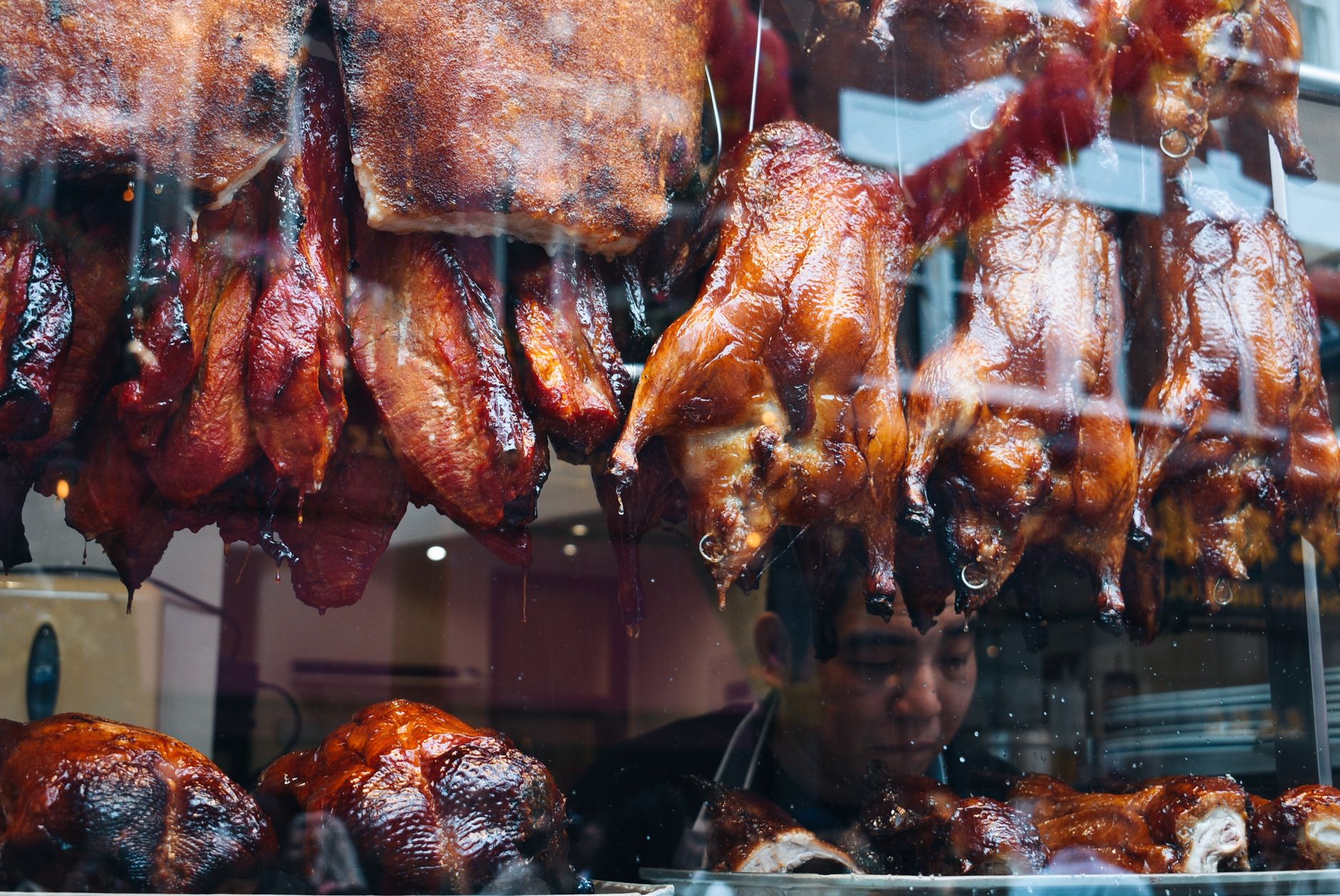 A vibrant display of roasted ducks and pork in a traditional Chinese deli.