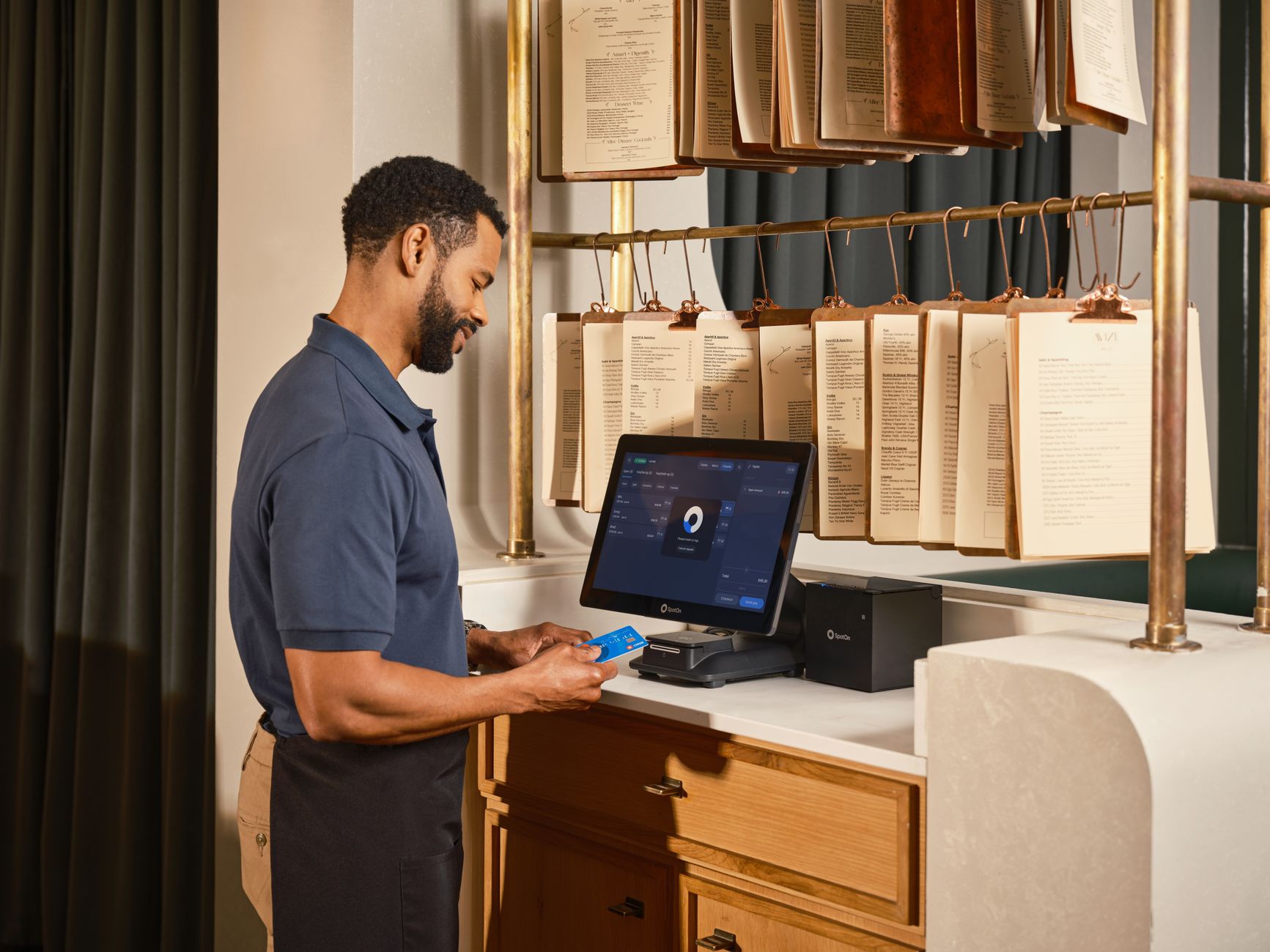 Server using a point of sale system to process a credit card payment in a restaurant setting.